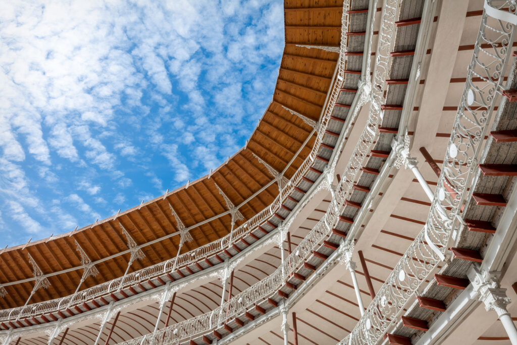 Vuelo interno de la cubierta del graderío a modo de marquesina con entablado de madera sobre cartelas de hierro forjado. Fotografía del vuelo interno de la cubierta del graderío a modo de marquesina con entablado de madera sobre cartelas de hierro forjado.